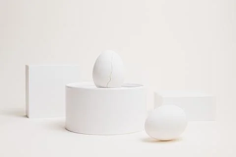 Two white eggs on geometric blocks, high key composition Stock Photos