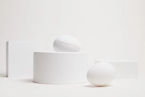 Two white eggs on geometric blocks, high key composition Stock Photos