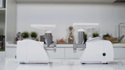 Two white electric meat grinders on white table in kitchen at home. Electric Stock Footage 130247196