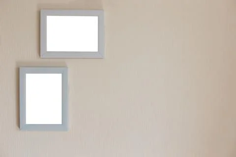 Two white frames on a beige wall Stock Photos