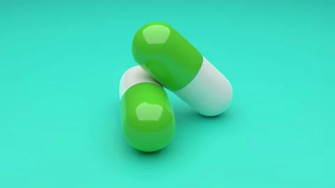 Two white-green pills rotating on green background. Video stock 132947653