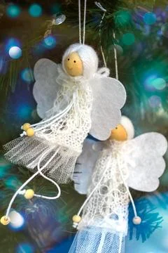 Two white hand-made angels decorate Christmas tree Stock Photos