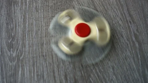 Two white hand spinner spinning on grey background or fidget spinners Stock Footage 76541610