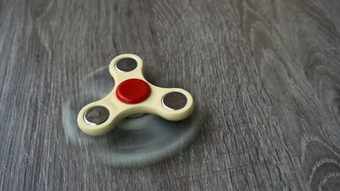 Two white hand spinner spinning on grey background or fidget spinners Stock Footage 76543055