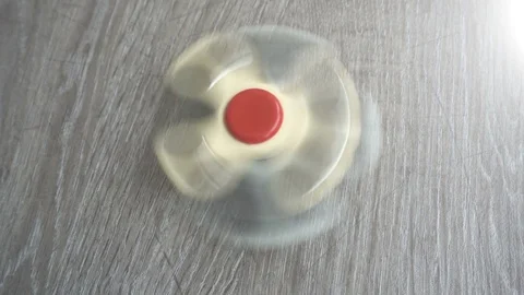 Two white hand spinner spinning on grey background or fidget spinners Stock Footage 76552501