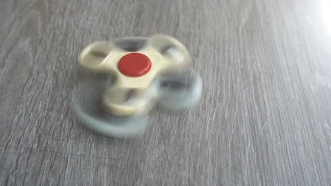 Two white hand spinner spinning on grey background or fidget spinners Stock-Footage 76561018
