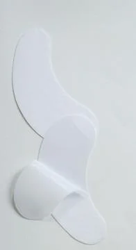 Two white lint free hydrogel eye patches with one partially peeled from its b Stock Photos