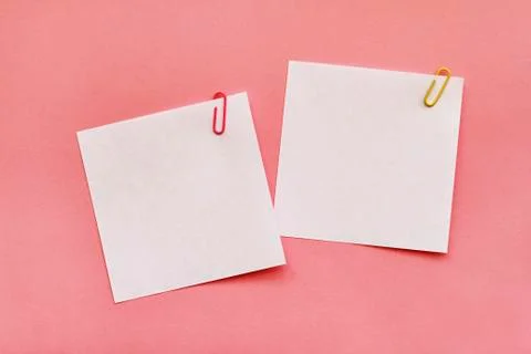 Two white note papers with clips on pink background Stock Photos
