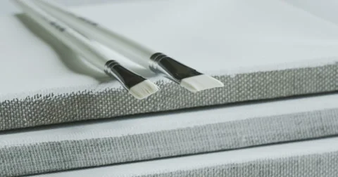 Two white paintbrushes and three canvas. Stock Footage 49863863