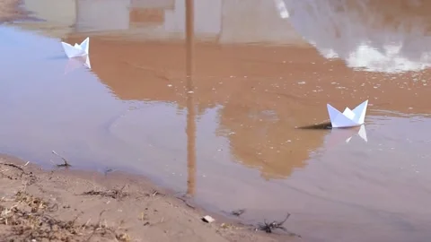 Two white paper boats float in a muddy spring puddle. Stock Footage 152085411