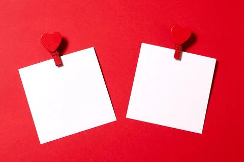 Two white paper sheets pinned with clothespin decorated with wooden hearts. R Stock Photos