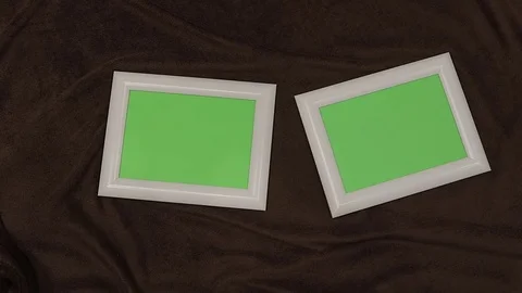 Two white photo frames with a green screen lies on a fluffy fabric. Stock Footage 80428389