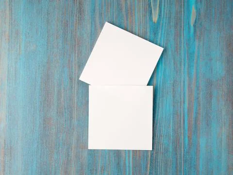Two white piece of paper for notes, square shape for record reminders on a blue Stock Photos