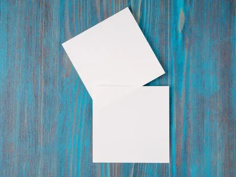 Two white piece of paper for notes, square shape for record reminders on a blue Stock Photos