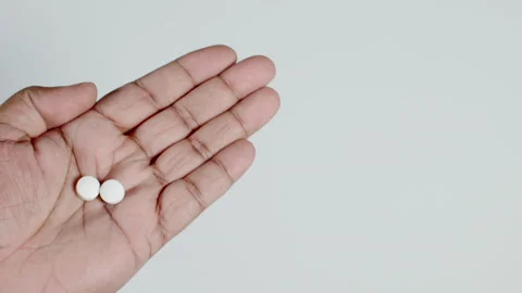 Two White Pills In a Hand Stock Footage 248756491