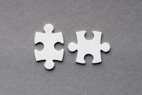 Two white puzzle pieces on gray background Stock Photos