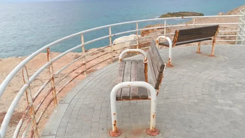 Two white rusty bench on the seashore, on a cliff, which is fenced Stock Footage 134638730
