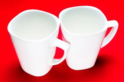 Two white square cup on a red background Stock Photos
