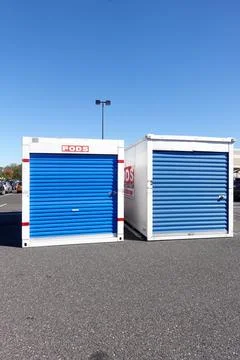 Two white storage pod containers with a blue door on a asphalt road Stock Photos
