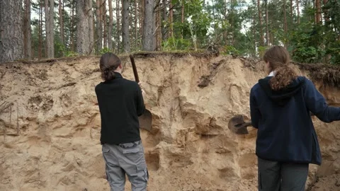 Two white teens sampling sand cliff Stock Footage 338169018