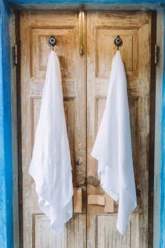 Two white towels hanging on rustic hangers in the bathroom Photos