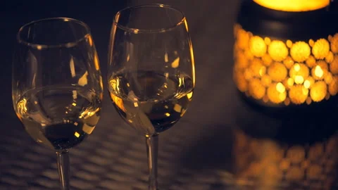 Two white wine wineglasses with  lantern with lighted candle on table. Stock Footage 90367040