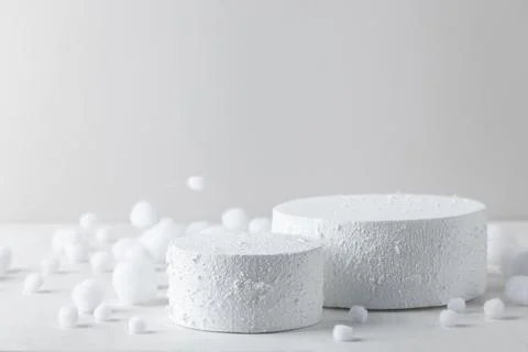 Two white winter podiums surrounded by scattered snow pieces for Christmas .. Stockfoto's