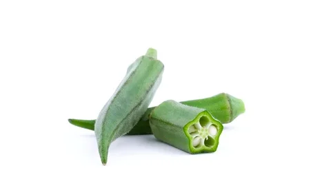 Two whole and one half of green okra. Rotating on the turntable. Isolated Video stock 93858149