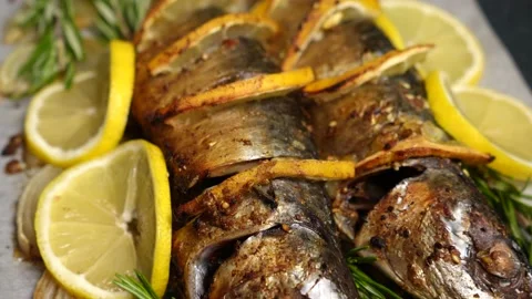 Two whole baked fish with lemon and rosemary close-up. Stock Footage 233356312
