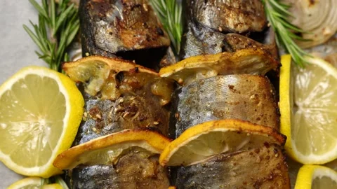 Two whole baked fish with lemon and rosemary close-up Stock Footage 233599596