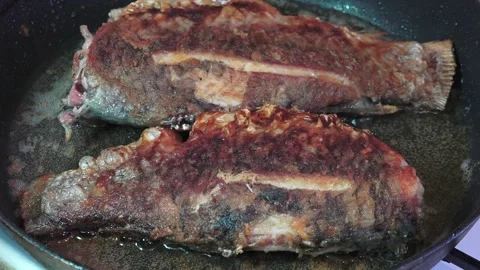Two Whole Fish Frying in a Pan. Original sound. Stock Footage 340551000