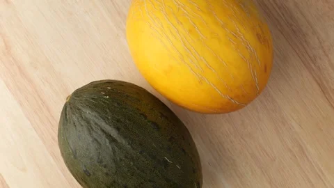 Two whole green and yellow melons rotating Stock Footage 343435552
