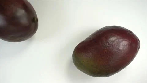 Two whole mango rotate in slow motion Stock Footage 142510741