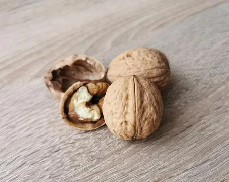 Two whole walnuts and one cracked walnut Stock Photos