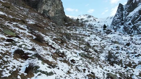 Two wild chamois (animals) running in snowy mountain. Wildlife drone flight, 4K Stock Footage 148031495