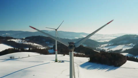 Two wind power generators in snow covered field aerial footage Stock Footage 343099164