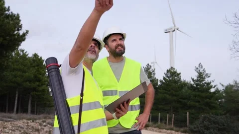 Two Wind Technicians Discussing Project Near Turbines Stock-Footage 276312492