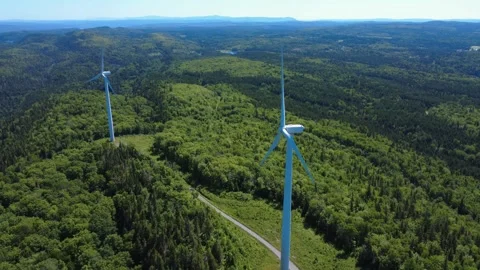 Two wind turbines powered by the wind in symbiosis with the natural elements. Stock Footage 317650833