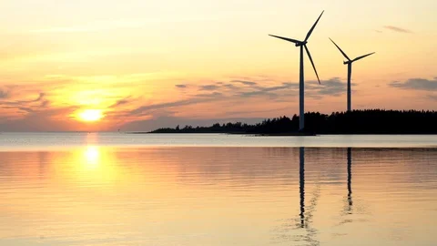 Two wind turbines, silhouettes at sunset on the Baltic sea 動画素材 117351344