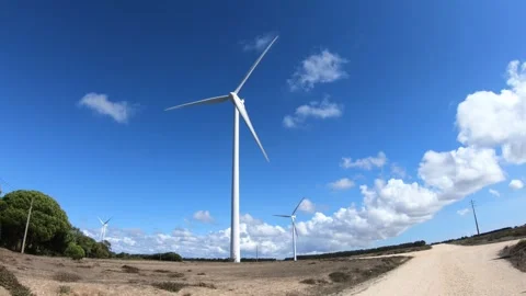 Two wind turbines spinning to generate clean energy against a clear blue sky. Vídeos de archivo 249464445
