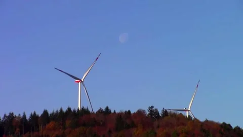 Two wind turbines standing on a forest hilltop Stock Footage 145652171