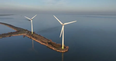 Two wind turbines at sunset, Marken, The Netherlands. Stockbeeldmateriaal 304817511