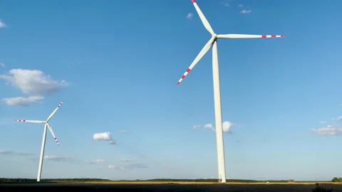 Two windmills on blue sky background, generation electricity from wind energy. Vidéo 235627840