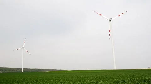 Two windmills rotating during windy spring cloudy day Stock Footage 62497270