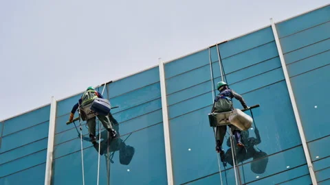 Two Window Cleaners on Glass Skyscraper Corner High Altitude Stock Footage 340241673