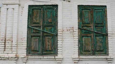 Two window openings on the wall with closed shutters Stock Photos