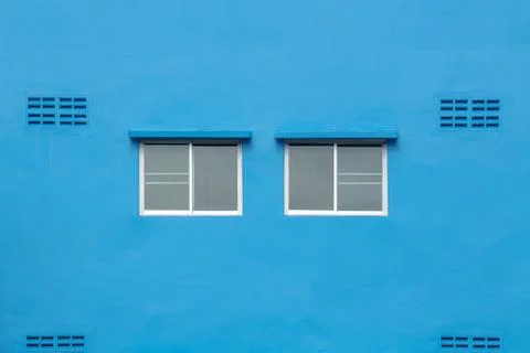 Two windows on the blue wall. Foto stock