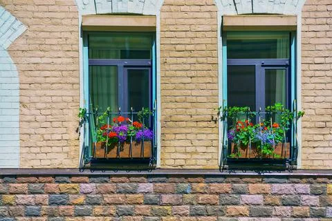 Two windows in a brick house with flower boxes Stock Photos