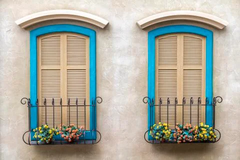 Two windows, with bright blue frames, and shutters on the glass. Stock Photos