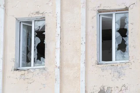 Two windows on the facade of the house with blown-out windows Stock Photos